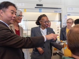 people in a laboratory, one of them pointing toward a computer screen