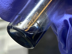 The purple/blue solution in this vial contains crystals of the berkelocene “sandwich.” 