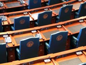 arcing rows of empty chairs in a legislative chamber