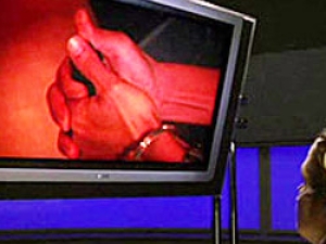 image of hands clutched with handcuffs on monitor