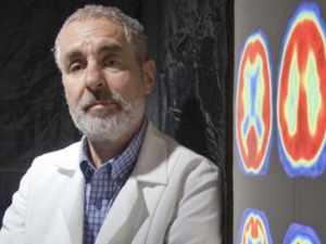William Jagust standing aside images of brain scans