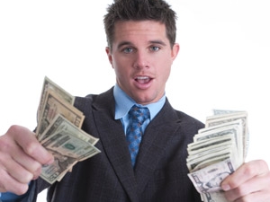 man holding piles of cash in both hands in front of him