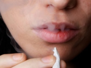 A woman smokes a cigarette.