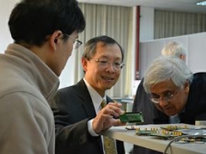 3 people looking at a device on a table