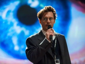man with microphone standing in front of an eye graphic in background
