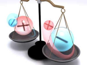 graphic of scales with red balls with plus sign and blue balls with negative sign